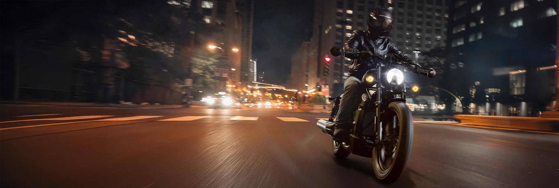 Un motociclistas en Moto de Lujo Harley Davidson, en la ciudad de noche a toda velocidad